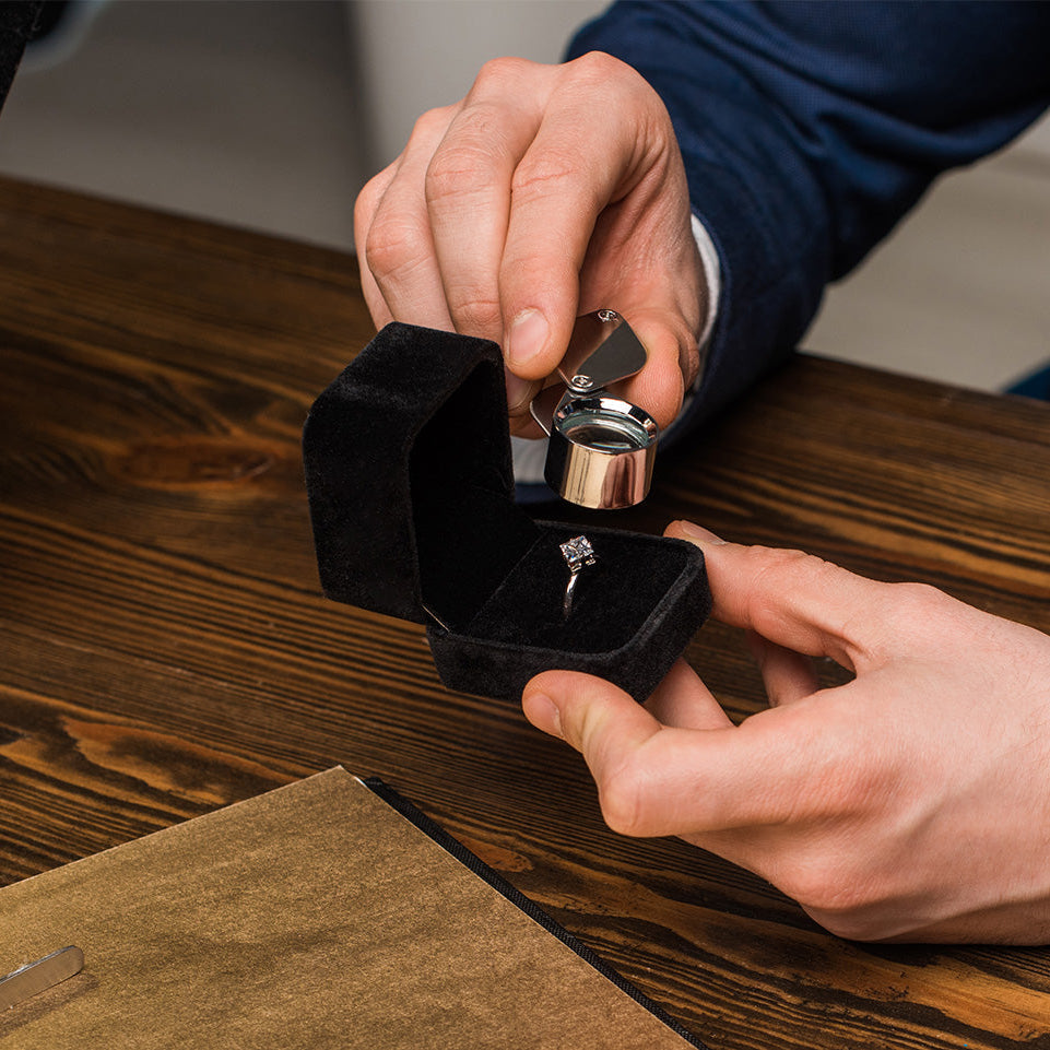A man uses a magnifier to view lab-grown vs. natural diamonds