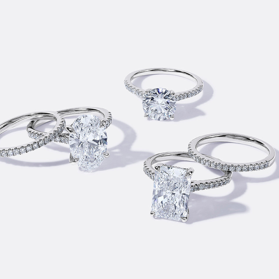 Five scattered white gold rings, including three engagement rings of different styles