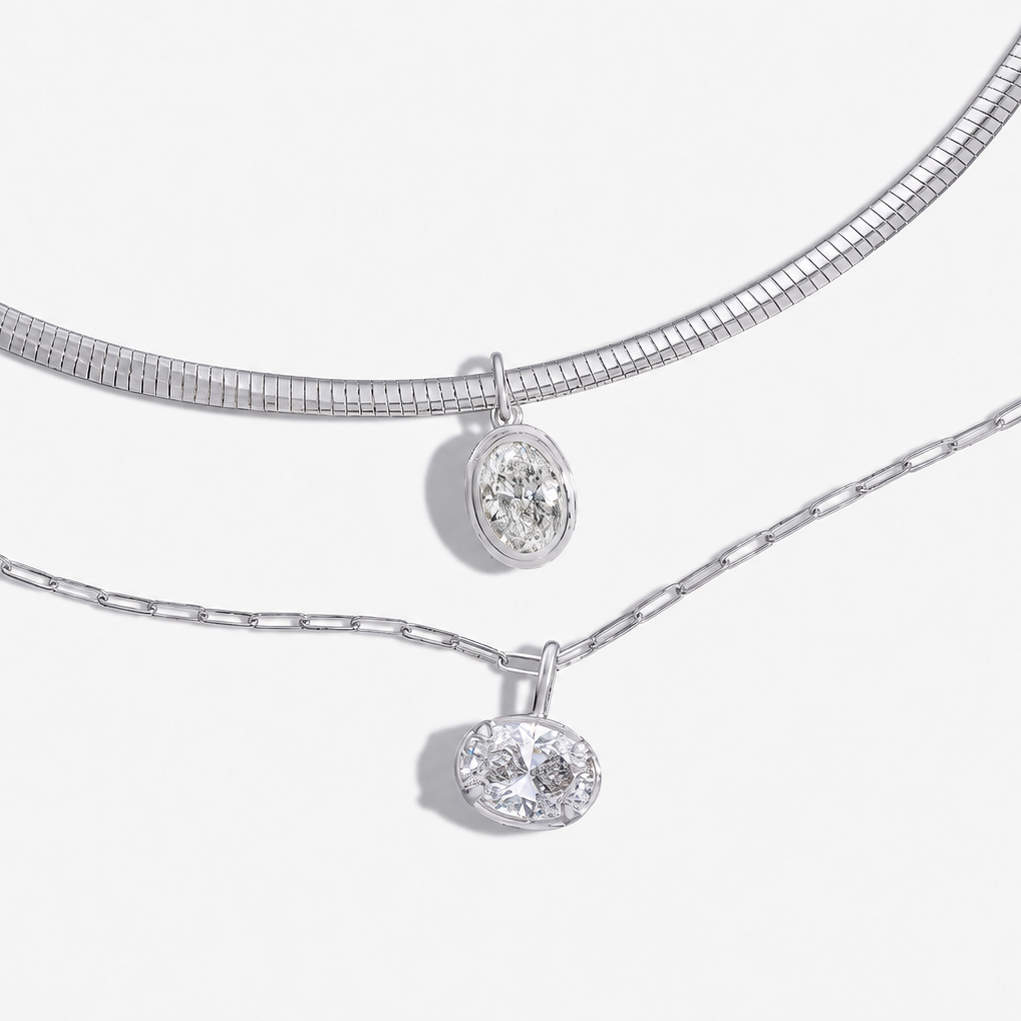 Flatlay of two pendant necklaces comparing platinum vs white gold