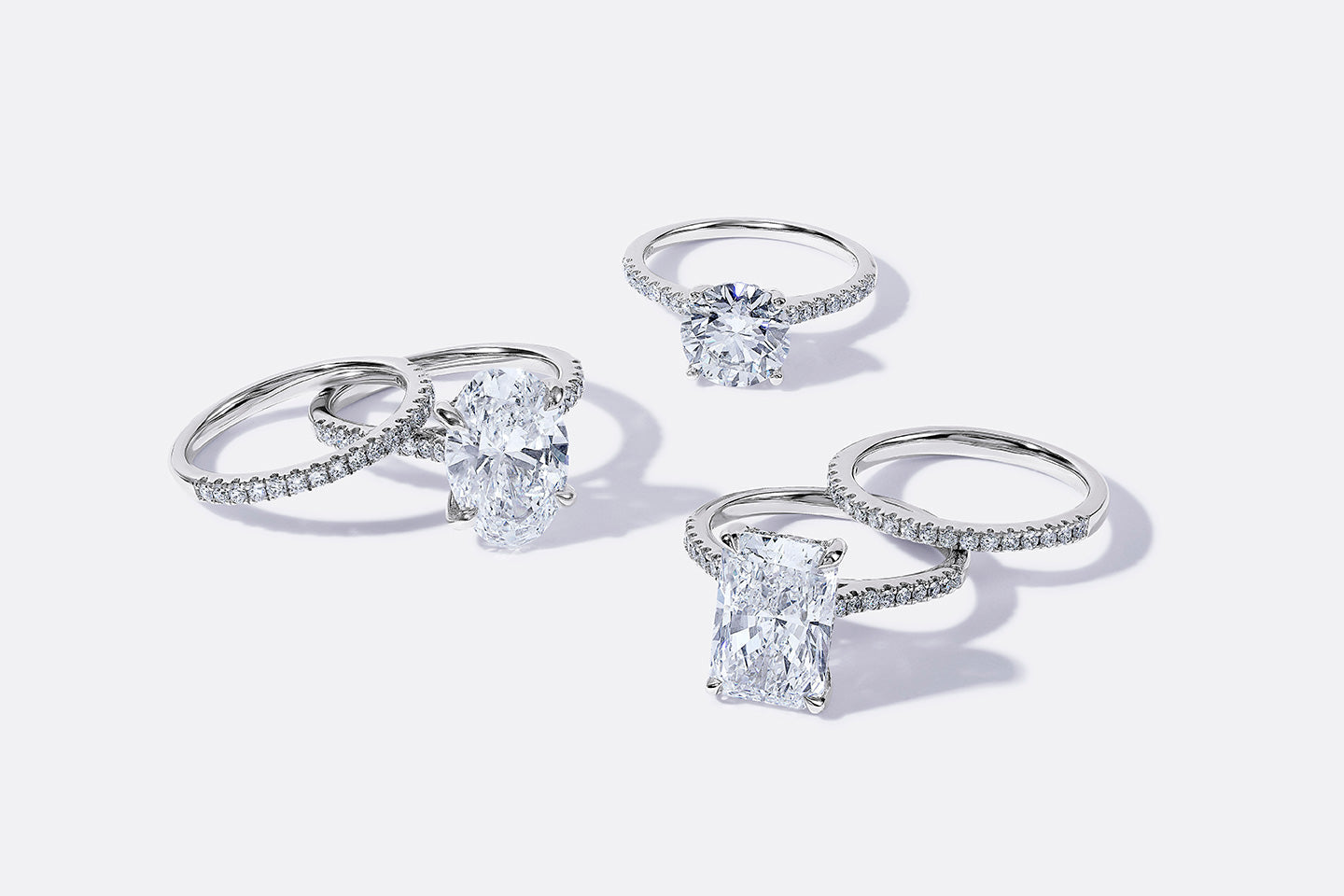 Five scattered white gold rings, including three engagement rings of different styles