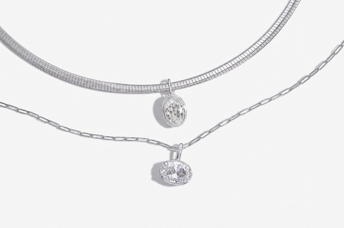 Flatlay of two pendant necklaces comparing platinum vs white gold