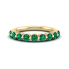 Gold ring with green gemstones on a white background