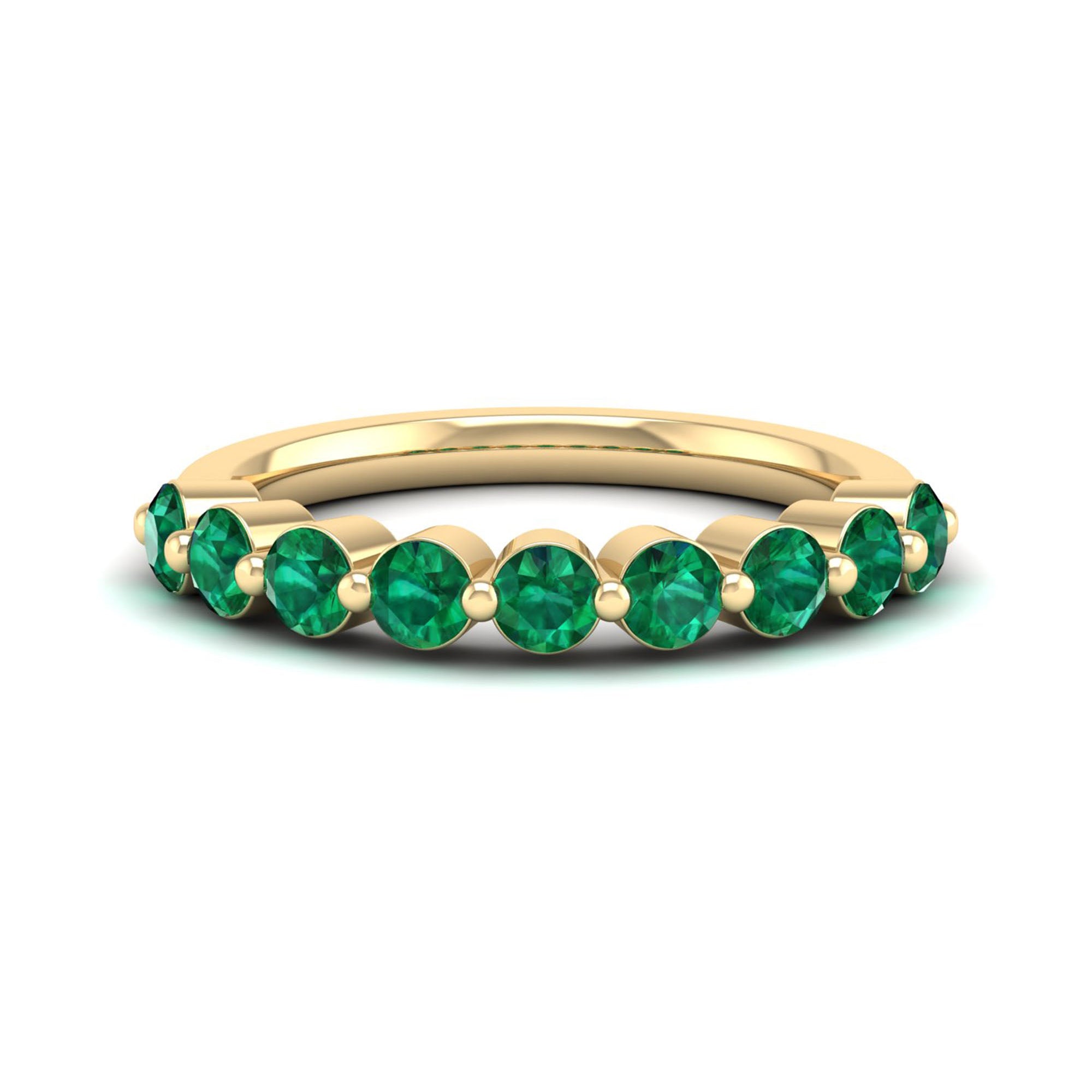 Gold ring with green gemstones on a white background
